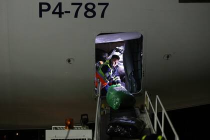 Los empleados del aeropuerto Chopin, de Varsovia, descargan las donaciones que llegaron desde Buenos Aires
