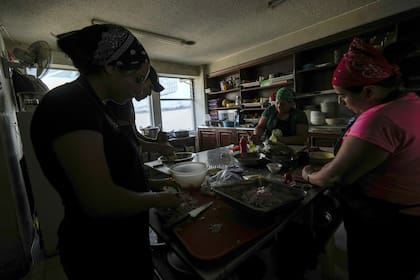 Los empleados del restaurante continúan con su trabajo utilizando herramientas manuales de cocina debido a los cortes de energía por parte del Ministerio de Energía, en Quito, Ecuador, el martes 16 de abril de 2024.