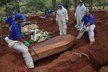 Los empleados entierran a una persona que murió presuntamente por Covid-19 en el cementerio de Vila Formosa, en las afueras de Sao Paulo, Brasil, el 31 de marzo de 2020