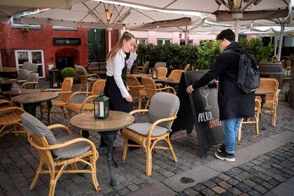 Los empleados preparan la terraza del restaurante Boef Ost en la plaza Graabroedre en Copenhague antes de su reapertura el 18 de mayo de 2020