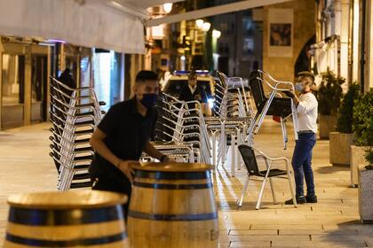 Los empleados se preparan para cerrar un bar al final de una jornada de trabajo en la Plaza Mayor de Madrid el 24 de octubre de 2020