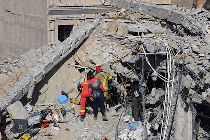 Los equipos de rescate buscan cuerpos entre los escombros de un edificio residencial tras un ataque aéreo ocurrido en la madrugada del 27 de marzo de 2026 en Teherán, Irán. (Foto de Majid Saeedi/Getty Images)