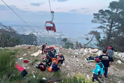 Los equipos de rescate realizando una operación de rescate y ayudando a las personas heridas después de que la cabina de un teleférico se estrellara contra un poste de cable caído en el distrito de Konyaalti