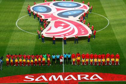 Los equipos escuchan los himnos antes del partido