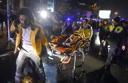 Los equipos médicos evacuan a una de las heridas en la disco Reina, donde un terrorista mató a 39 personas
