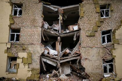 Los escombros cuelgan de un edificio residencial gravemente dañado por un bombardeo ruso en Bakhmut, en el este de Ucrania, el sábado 28 de mayo de 2022. Los combates se han desatado en Lysychansk y la vecina Sievierodonetsk, las últimas ciudades importantes bajo control ucraniano en la región de Lugansk. (AP Photo/Francisco Seco)