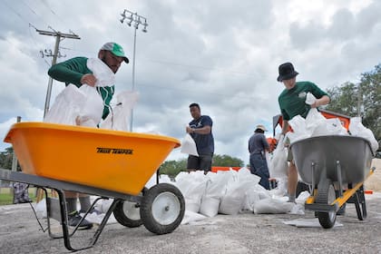 Los esidentes de Tampa, Florida, colocan costales de arena para prevenir inundaciones en zonas bajas antes de la llegada del huracán Idalia