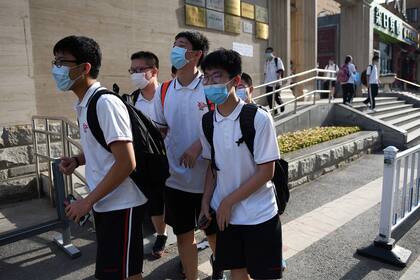 Los estudiantes de secundaria con mascarillas se van a sus hogares al final de su día escolar en Pekín el 12 de junio de 2020