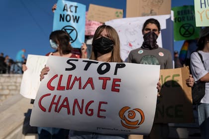 Los estudiantes sostienen pancartas durante una manifestación contra el calentamiento global frente al parlamento en Atenas, el viernes 24 de septiembre de 2021