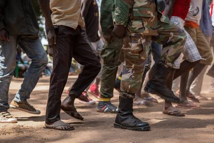Los ex niños soldados reaccionan cuando llegan con sus comandantes para asistir a la ceremonia de liberación