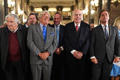 Los ex presidentes uruguayos José Mujica (2010-2015), Luis Alberto Lacalle (1990-1995), Julio María Sanguinetti (1985-1990, 1995-2000), y el actual presidente Luis Lacalle Pou gesticulan antes de cantar el himno nacional tras una sesión parlamentaria en conmemoración del 50 aniversario del inicio de la dictadura uruguaya (1973-1985) en el Palacio Legislativo de Montevideo, el 26 de junio de 2023. 