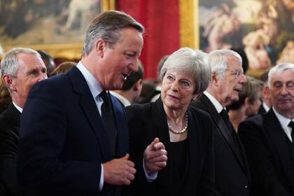Los ex primeros ministros de Gran Bretaña, Theresa May y David Cameron