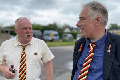 Los exalumnos de la escuela Stephen Nicholls y Richard Warwick llevan corbatas con los colores que usan en homenaje los muertos por el caso: rojo por el VIH, amarillo por la hepatitis, y negro por la muerte.