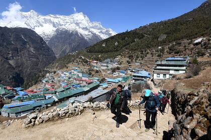 Los excursionistas caminan por un sendero en la ciudad de Namche Bazar en la región del Everest del distrito de Solukhumbu el 25 de abril de 2021