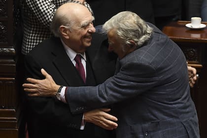 Los expresidentes uruguayos Julio Sanguinetti y José Mujica se abrazan durante su última sesión como senadores en el Congreso de Montevideo