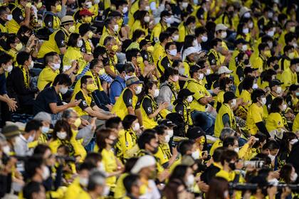 Los fanáticos usan tapabocas mientras ven el partido de fútbol de la J-League el 19 de septiembre de 2020