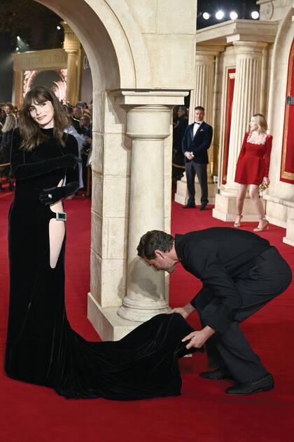 Los fotográfos capturan el momento exacto en que el actor se ocupa del vestido de su hermana.