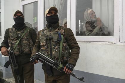 Policías indios vigilan mientras los musulmanes de Cachemira rezan con motivo del aniversario del nacimiento del Profeta Mahoma en Srinagar