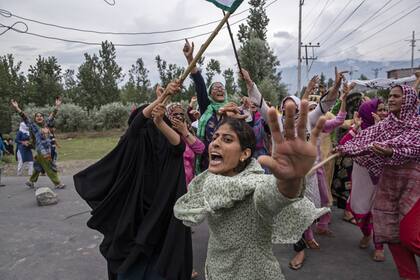 Las mujeres gritan consignas mientras los policías indios disparan gases lacrimógenos y municiones en el aire para detener una marcha de protesta en Srinagar
