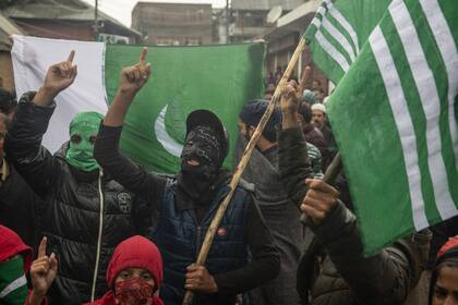 Los cachemires enmascarados gritan consignas durante una protesta después de las oraciones del viernes en las afueras de Srinagar