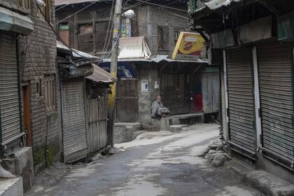 Un anciano de Cachemira se sienta afuera de un mercado cerrado durante una huelga en Srinagar,