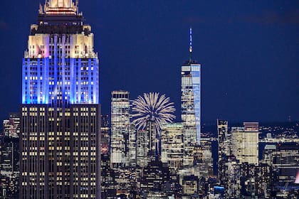 Los fuegos artificiales explotan detrás de los edificios emblemáticos del horizonte de la ciudad de Manhattan, incluido el Empire State Building (L) y el One World Trade Center