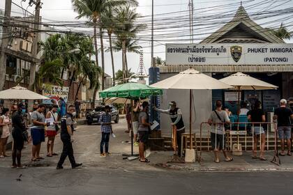 Los funcionarios de inmigración intentan ayudar a los turistas en Phuket, Tailandia, que están varados y buscan extender sus visas el lunes 30 de marzo de 2020