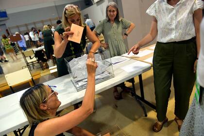 Los funcionarios electorales vacían una urna para contar los votos en un colegio electoral en Pamplona, norte de España, el domingo 23 de julio de 2023