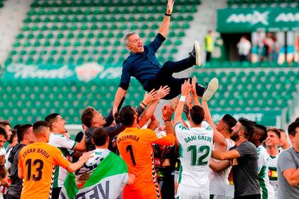 Los futbolistas de Elche levantan por el aire al entrenador, Fran Escribá, luego de consumar la permanencia en la Liga de España tras vencer a Athletic de Bilbao.