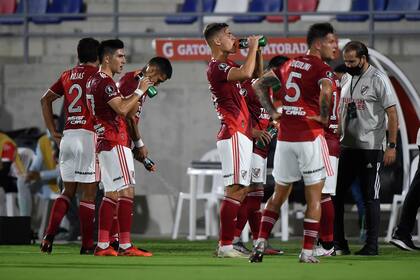 Los futbolistas de River se refrescan, durante la interrupción que sufrió el partido por los gases lacrimógenos que llegaron al campo de juego, proveniente de los graves incidentes que se producían al mismo tiempo fuera del estadio