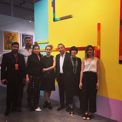 Los galeristas de la sección dedicada a la Argentina, con Diego Costa Peuser y la curadora Florencia Battiti, y obra de Román Vitali