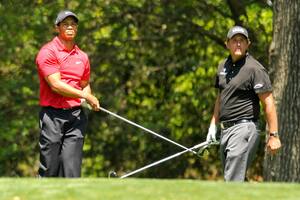 Los golfistas estadounidenses Tiger Woods (izq.) y Phil Mickelson miran el golpe de salida de Woods en el segundo hoyo durante la ronda final del US Masters en el Augusta National Golf Club el 12 de abril de 2009.