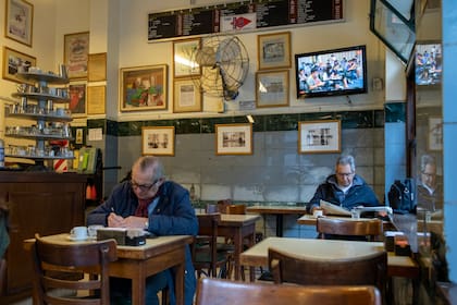 Los habitués disfrutan del ambiente del bar. Algunos se inspiran, otros leen los diarios del día.
