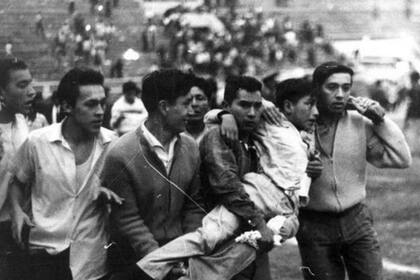 Los heridos son socorridos en pleno estadio Nacional de Lima: jugaban Perú y Argentina en 1964 por un lugar en los Juegos Olímpicos de ese año y se suspendió por incidentes. Hubo 328 muertos y más de 500 heridos.