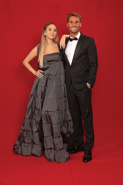 Los hermanos Bernarda y Luis Cella, hijos del histórico
productor de Susana. Ella lució un vestido en tafetán de seda natural color grafito,
con escote cuadrado sostenido por breteles anchos anudados en los hombros y
falda de corte imperio de Javier Saiach