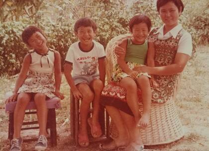 Los hermanos Kano: Claudio, María Inés y Alejandra, sobre la falda de su madre, Setsuko