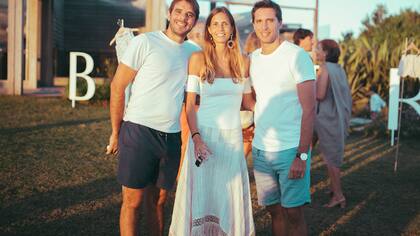 Los hermanos Pasaaglia, Santiago, Delfi y Manuel Passaglia combinados. Vestido off shoulder para ella y camisetas blancas para ellos, la camiseta básica es otra de las prendas del verano