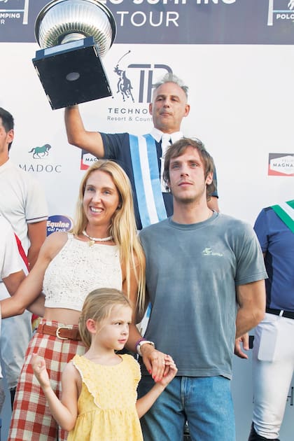 Los hermanos Strom, Isabelle y Robert, y la pequeña Olympia, posan en el podio junto al campeón, Leandro Moschini.