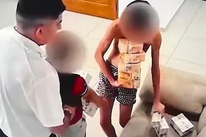 Los hijos de Fernando Ayala cargando fajos de dinero