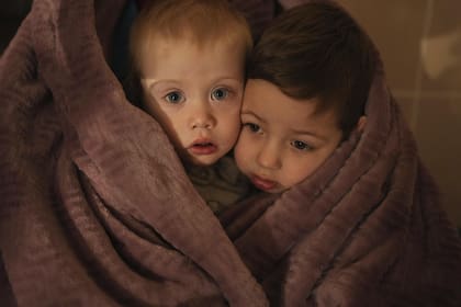 Los hijos de los trabajadores médicos se calientan con una manta mientras esperan a sus familiares en un hospital de Mariupol, Ucrania, el 4 de marzo de 2022.