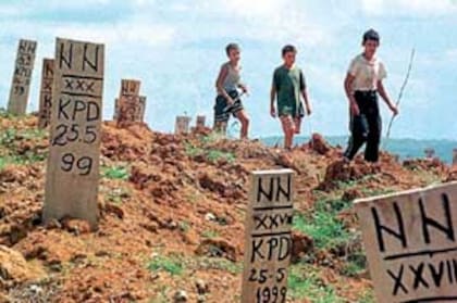Niños huérfanos recorren un cementerio improvisado en Bosnia, sembrado de tumbas de musulmanes enterrados sin identificar
