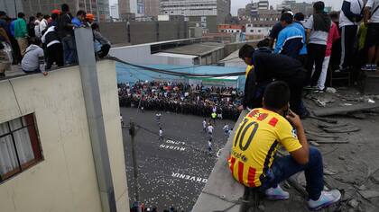 Los hincas pagan alrededor de $ 2 dólares para observan el partido desde la terraza de un edificio, durante el campeonato de fútbol callejero el Porvenir en Lima, Perú