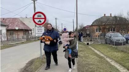 Los hombres esperan que lleguen los ucranianos desplazados.
