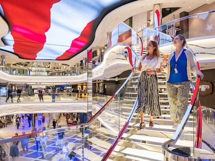 Los huéspedes disfrutan de bebidas en World Galleria a bordo del nuevo barco