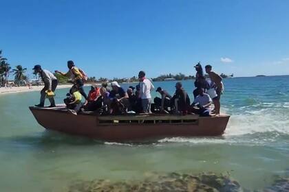 Los inmigrantes cubanos bajan a toda velocidad de la embarcación para tocar tierra firme en Florida y huir de la playa