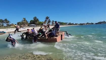 Los inmigrantes cubanos se abalanzan sobre la arena una vez que se acercan a la costa de Florida