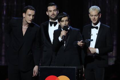 Los integrantes de la banda inglesa The 1975 Matthew Healy, Ross MacDonald, George Daniel y Adam Hann agredecieron anoche el Brit Award al mejor álbum del año
