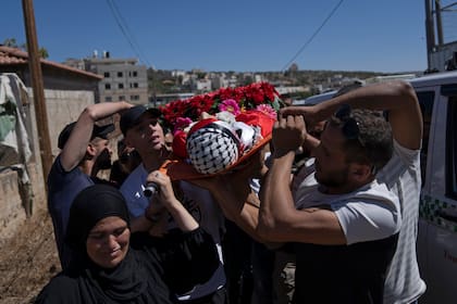 Los islámicos llevan sus muertos en una camilla, envueltos con mortaja (no utilizan féretro), y en el caso de un thaakil, los padres suelen encabezar el grupo que carga el cuerpo (AP Foto/Nasser Nasser)