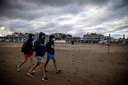 Los jóvenes con barbijos también se vieron a pocos metros del mar al que se metieron pocos por la baja de la temperatura del fin de semana