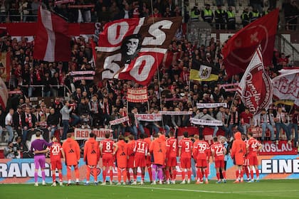 Los jugadores de Bayern celebran con hinchas tras la goleada a St. Pauli por la Bundesliga; el club bávaro puede conseguir por 35ª vez la corona.